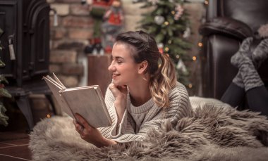 Kız şömine, eve geri kalan kavramı yakın rahat bir ev atmosferde bir kitap okuma