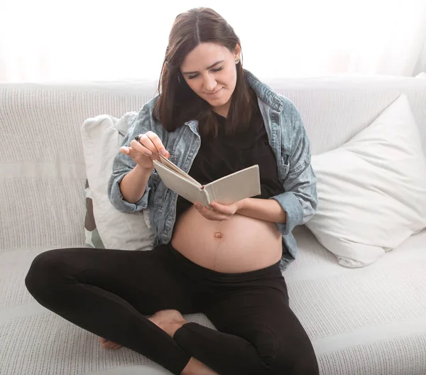 Joven Mujer Embarazada Hermosa Sentada Sofá Leyendo Libro Casa Por — Foto de Stock