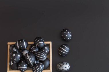 Siyah ve beyaz el yapımı desen ahşap kutusunda siyah arka plan üzerinde Paskalya tatil kavramı izole Paskalya yortusu yumurta