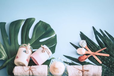 Spa öğelerle bir renk mavi arka plan bir tropikal yaprak, vücut bakımı ve spa bakımları kavramı ile ilgili kompozisyon