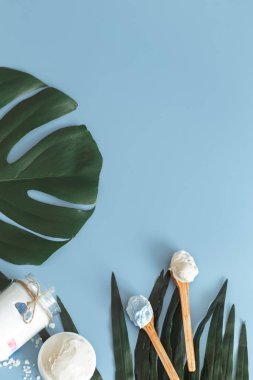 Spa öğelerle bir renk mavi arka plan bir tropikal yaprak, vücut bakımı ve spa bakımları kavramı ile ilgili kompozisyon