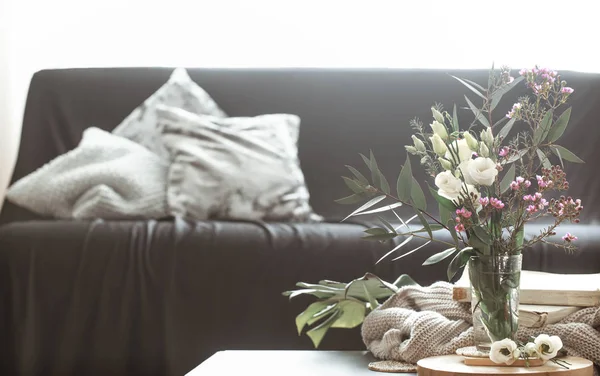 舒适的家庭内部客厅 配有黑色沙发和小桌子上有鲜花和装饰物品的花瓶 — 图库照片