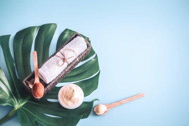 Spa öğelerle bir renk mavi arka plan bir tropikal yaprak, vücut bakımı ve spa bakımları kavramı ile ilgili kompozisyon