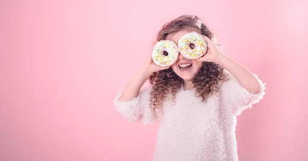 Kıvırcık Saçları Onun Elinde Iki Iştah Açıcı Donut Ile Küçük — Stok fotoğraf