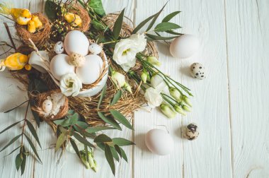 Mutlu Paskalya arka plan. Paskalya yumurtaları bir fincan çiçek dekorasyonu ile ahşap beyaz zemin üzerinde. Bıldırcın yumurtası. Mutlu Paskalya kavramı