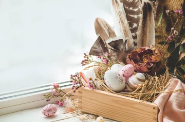 Mutlu Paskalya arka plan. Pembe Paskalya yumurtaları bir yuvaya çiçek süslemeleri ve pencerenin yakınındaki tüyleri ile. Bıldırcın yumurtası. Mutlu Paskalya kavramı.