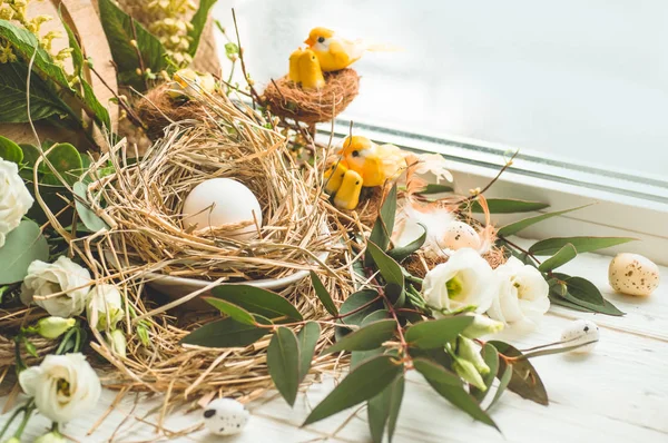 Happy Easter background. Easter egg in a nest with floral decoration near the window. Quail eggs. Happy Easter concept.