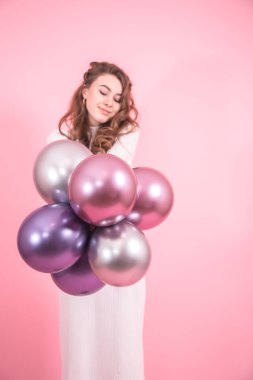 Genç kız pembe renkli arka plan üzerinde güzel topları ile giyinmiş beyaz bir elbise, kadınlar günü ve tatil kavramı