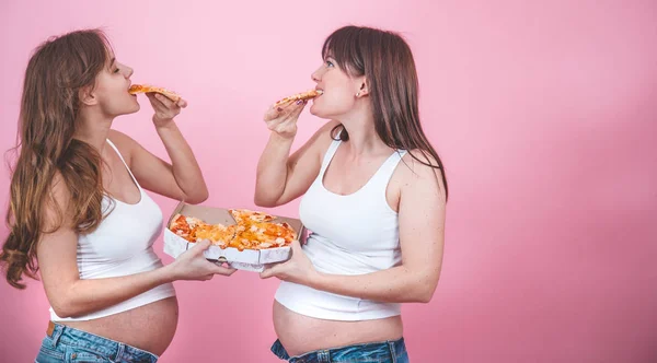 Концепция Питания Две Красивые Беременные Женщины Едят Пиццу Розовом Фоне — стоковое фото