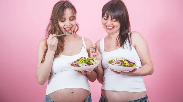 Концепция Материнства Две Беременные Женщины Едят Свежий Салат Розовом Фоне — стоковое фото