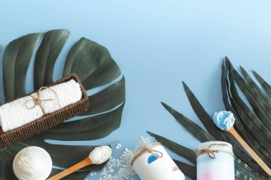 Spa öğelerle bir renk mavi arka plan bir tropikal yaprak, vücut bakımı ve spa bakımları kavramı ile ilgili kompozisyon
