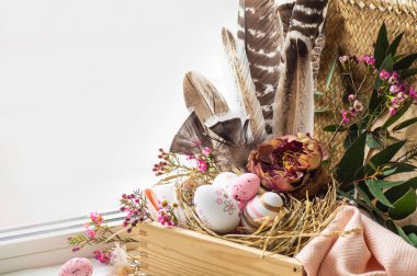 Mutlu Paskalya arka plan. Pembe Paskalya yumurtaları bir yuvaya çiçek süslemeleri ve pencerenin yakınındaki tüyleri ile. Bıldırcın yumurtası. Mutlu Paskalya kavramı.