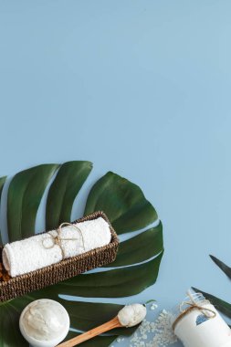 Spa öğelerle bir renk mavi arka plan bir tropikal yaprak, vücut bakımı ve spa bakımları kavramı ile ilgili kompozisyon