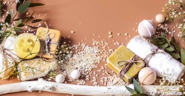 Havlu, sabun, tuz, yaprak, çiçek, banyo bombalar ve renkli arka plan üzerinde vücut ve yüz aksesuarları Spa kavramı. Metin için yer