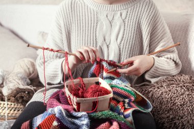 tahta tekerlek teli ve rahat bir kanepe bir kadını elinde kırmızı iplik. Still life fotoğraf. Konfor kavramını