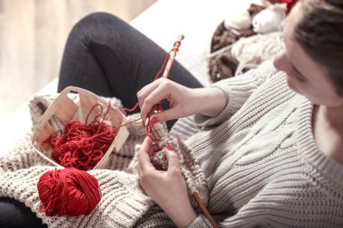 tahta tekerlek teli ve rahat bir kanepe bir kadını elinde kırmızı iplik. Still life fotoğraf. Konfor kavramını
