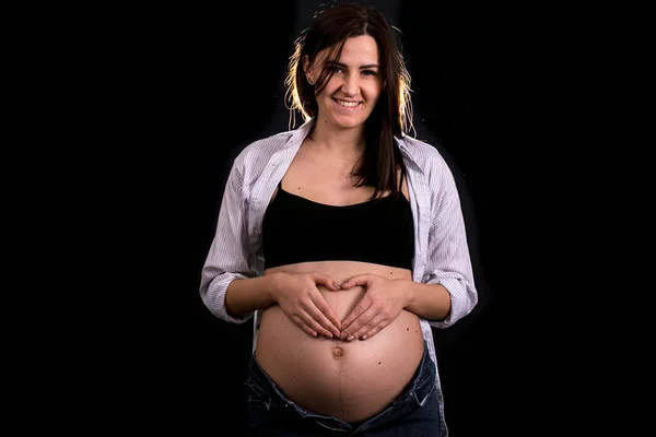 黒の背景 子供を見越しての概念に妊娠中の女性の肖像画 — ストック写真