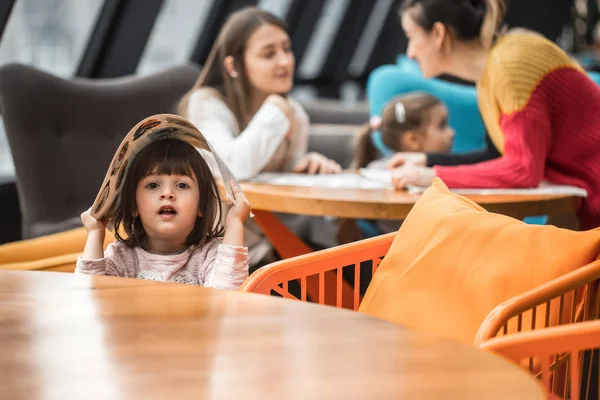 Ένα Πανέμορφο Κοριτσάκι Καθόταν Ένα Ξύλινο Τραπέζι Ένα Μενού Στο — Φωτογραφία Αρχείου