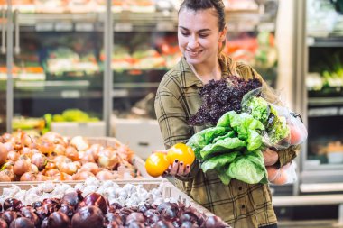 Marketteki kadın. Bir süpermarkette alışveriş ve taze organik sebze satın alma güzel ve genç birbayan. Sağlıklı beslenme kavramı. Hasat