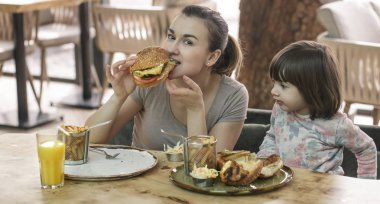 Bir kafede hızlı yemek yeme şirin kızı olan anne