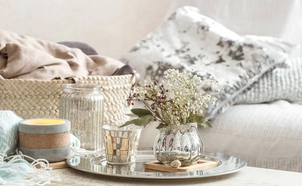 Thuis decoraties in het interieur. Een turquoise deken en rieten mand met een vaas met bloemen en kaarsen — Stockfoto
