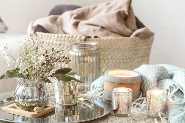 Thuis decoraties in het interieur. Een turquoise deken en rieten mand met een vaas met bloemen en kaarsen — Stockfoto