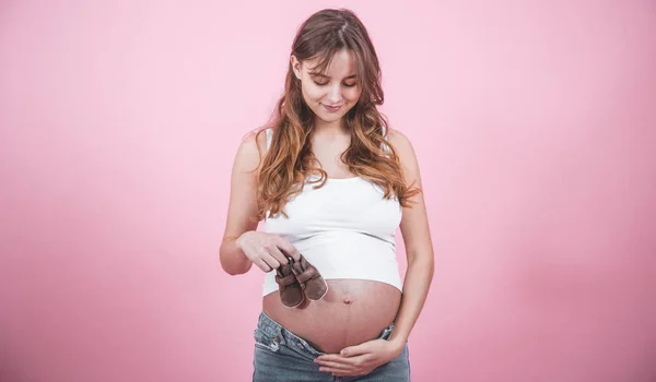 Mutterschaftskonzept, schwangere Frau mit Hausschuhen in der Hand — Stockfoto