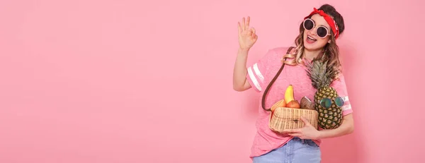 Девушка в розовой футболке и очках, держит в руках полный комплект — стоковое фото