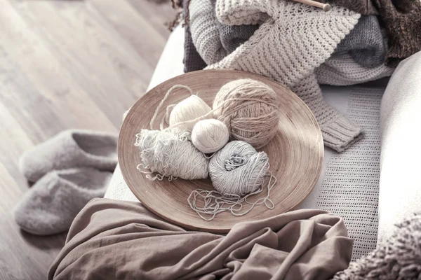 Ferri da maglia in legno vintage e fili su un accogliente divano con — Foto Stock
