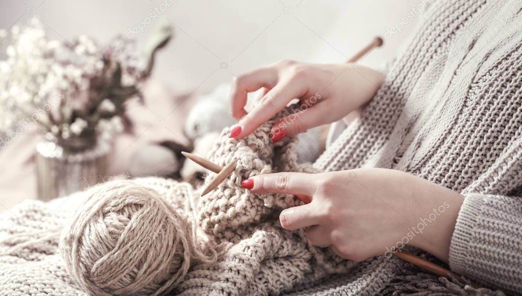 Vintage wooden knitting needles and yarn in woman's hands