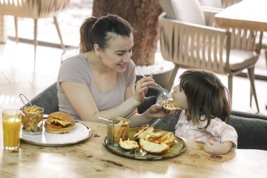Bir kafede hızlı yemek yeme şirin kızı olan anne