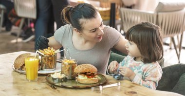 Bir kafede hızlı yemek yeme şirin kızı olan anne