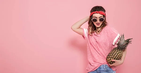 Портрет девушки-хипстера в очках и ананасе на розовом бэкгре — стоковое фото