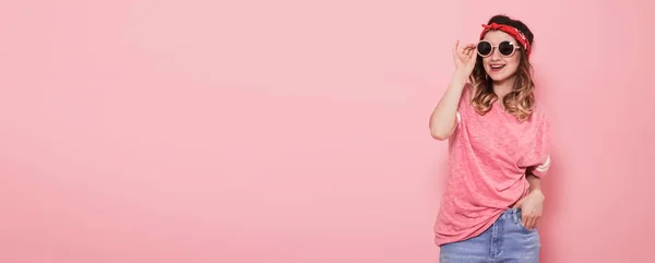 Красивая молодая девушка в розовой футболке на розовом фоне — стоковое фото