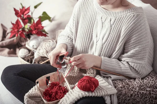 Woman knits knitting needles on the couch — Stock Photo, Image