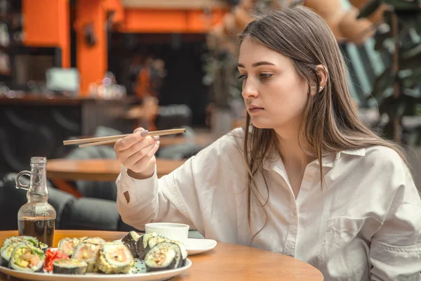 Mujer joven comiendo y disfrutando de sushi fresco — Foto de Stock