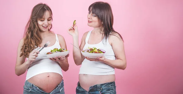 Концепция материнства, две беременные женщины едят свежий салат — стоковое фото
