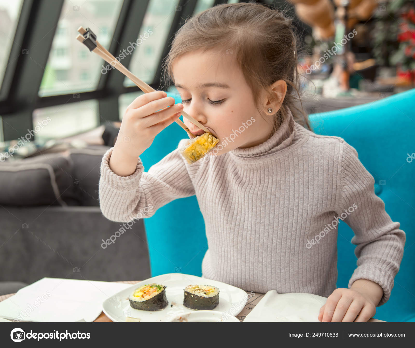 Encantadora garota engraçada comer sushi em um restaurante — Foto © puhimec  #249710638, image size:1600x1342
