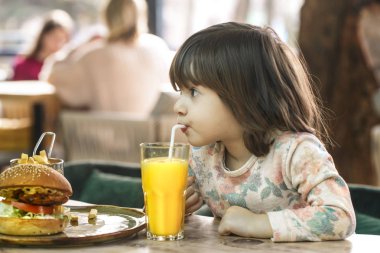 Küçük kız bir lokanta kafede yiyor