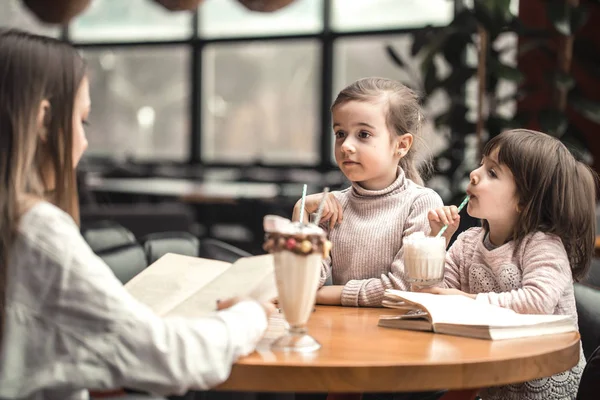Μητέρα ευτυχισμένη νεαρές γυναίκες με παιδιά που κάθονται στο τραπέζι και να μιλάμε σε εστιατόριο — Φωτογραφία Αρχείου