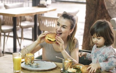 Bir kafede hızlı yemek yeme şirin kızı olan anne