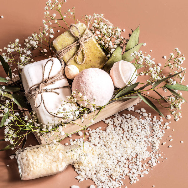 Top view of spa and body care accessories in wooden box on colored background.