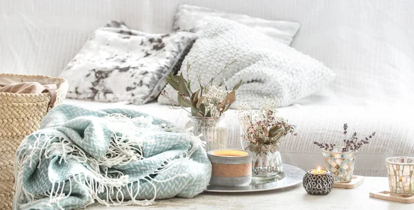 Внутреннее убранство. Бирюзовое одеяло и плетеная корзина с вазой цветов и свечей — стоковое фото