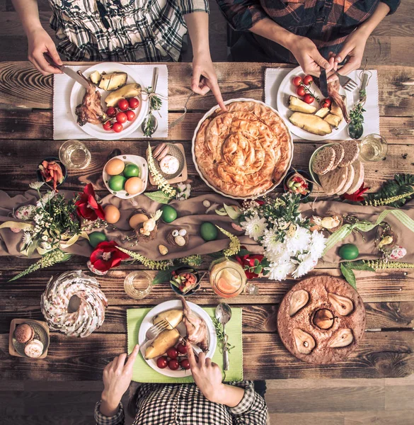 Holiday przyjaciółmi lub rodziną na świątecznym stole z mięsa króliczego, warzywa, ciasta, jaja, widok z góry. — Zdjęcie stockowe