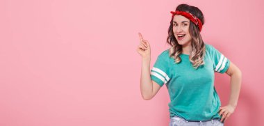 Yalıtılmış bir pembe arka tarafta parmağıyla işaret portre kız