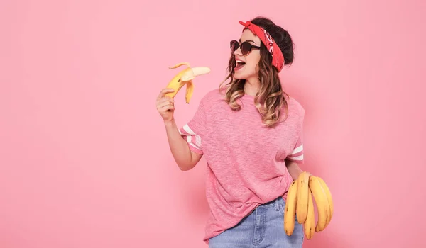 Портрет девушки и бананы на розовом фоне — стоковое фото