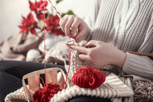 Mulher tricota agulhas de tricô no sofá — Fotografia de Stock