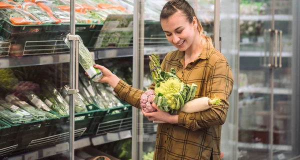 Marketteki kadın. Güzel ve genç birbayan tutan eller taze organik sebze ve buzdolabı süpermarkette açar — Stok fotoğraf