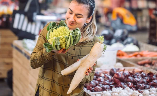Marketteki kadın. Taze organik sebze, lahana ve turp tutan güzel genç kadın — Stok fotoğraf