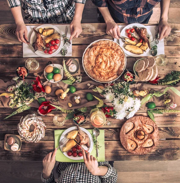 Holiday przyjaciółmi lub rodziną na świątecznym stole z mięsa króliczego, warzywa, ciasta, jaja, widok z góry. — Zdjęcie stockowe